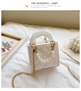 Detail der weißen Mini-Tasche aus Lackleder mit Perlengriff und goldener Kettenriemen