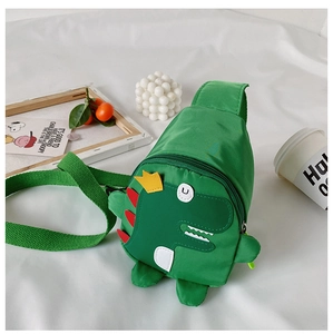 Detailed view of green dinosaur kid chest bag with adjustable strap and cartoon patches