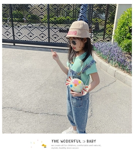 Outdoor street view of a creative candy-shaped crossbody bag on a child model with summer outfit