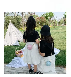 Pink and blue basketball shaped mini chain bags for kids in a natural outdoor setting