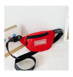 Détail du sac banane rouge pour enfant avec bandoulière lettrée et écusson tissé