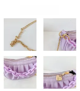 Détails du sac violet plissé avec chaîne acrylique et pendentif cœur doré sur le zip