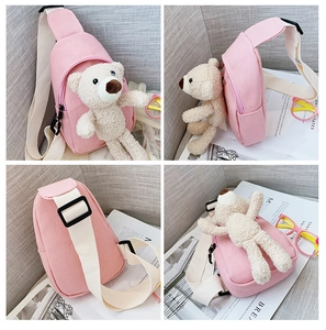 Detailed view of pink canvas crossbody bag for kids featuring a cute plush bear decoration