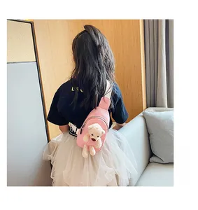 Pink canvas kids chest bag with 3D teddy bear charm shown on a girl from back view