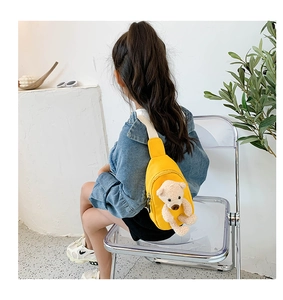 Close-up of bright yellow canvas kids chest bag with a cute 3D plush bear decoration