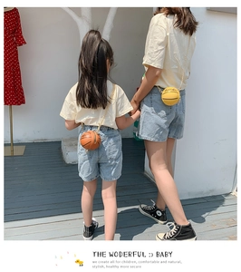 Outdoor shot of mother and daughter carrying stylish basketball shaped mini crossbody bags