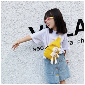 Close-up of a bright yellow kids canvas chest bag with a cute plush rabbit pendant