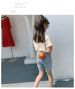 Outdoor shot of a creative basketball-shaped crossbody bag with gold chain strap for kids