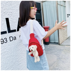 Detailed view of red canvas kids chest bag featuring a plush 3D teddy bear charm