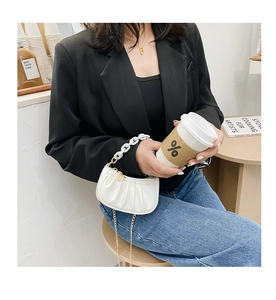 Vue détaillée d'un sac nuage plissé blanc avec chaîne en résine et pendentif cœur doré