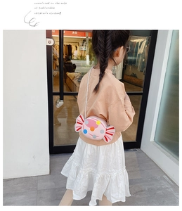 Pink candy-shaped kids crossbody bag with colorful dots shown on a young model