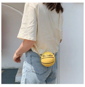 Detail of yellow basketball crossbody bag with gold chain worn by a child model