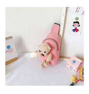 Detailed view of pink canvas chest bag with a cute beige plush teddy bear insert