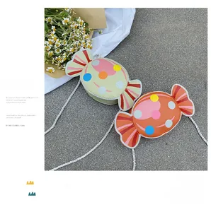 Detail of candy-shaped crossbody bags for kids with colorful polka dots and woven straps
