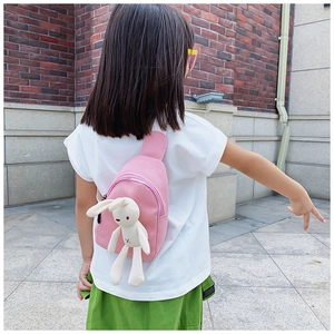 Pink canvas crossbody chest bag for kids featuring a cute plush bunny doll charm