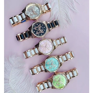 Vue de cinq montres papillon en céramique colorée avec des diamants et détails dorés