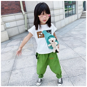 Detailed close-up of a teal kids crossbody chest bag with a cute plush bear charm