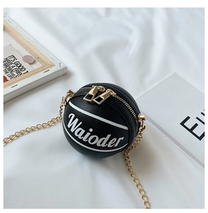 Detail view of mini basketball-shaped crossbody bag with gold chain and black pebble leather