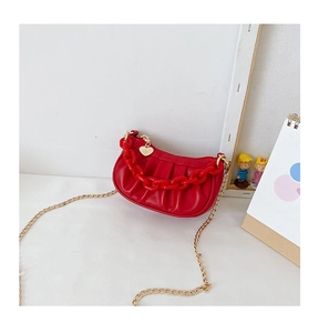 Détail du sac rouge plissé pour enfant avec chaîne en plastique et pendentif cœur