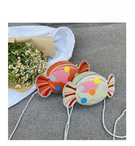 Detail of candy-shaped kids crossbody bags in orange and green with polka dots