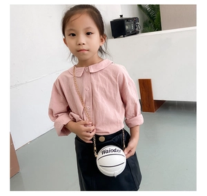 Detail einer weißen Mini-Tasche in Basketballform mit Goldkette an einem Mädchen