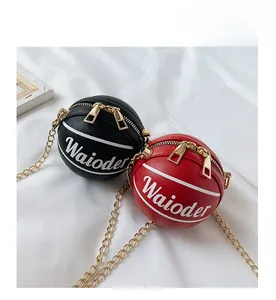 Detail of red and black basketball-shaped crossbody bags with gold chains and zipper