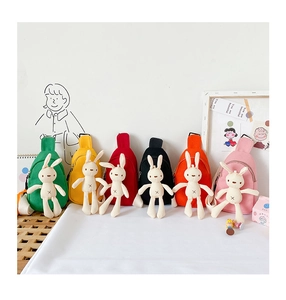 Detail of colorful canvas kids chest bags featuring detachable plush bunny dolls