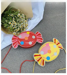 Close-up of red and yellow candy-shaped crossbody bags with colorful polka dots