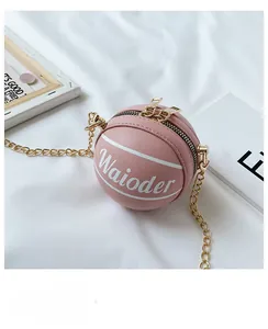 Close-up of pink basketball-shaped bag with gold chain strap and dual zipper closure