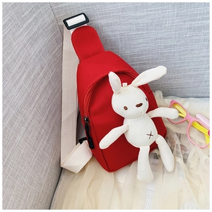 Detail of red canvas kids sling bag with cute plush bunny and adjustable strap