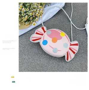 Detailed close-up of a pink candy-shaped kids crossbody bag with glittery colorful dots