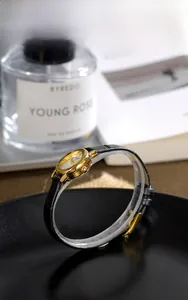 Detailed shot of an elegant vintage women's watch with golden oval case and black leather strap