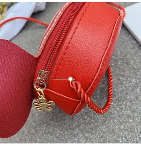 Detail of red cartoon snack bag showing lychee pattern PU leather and golden flower zipper