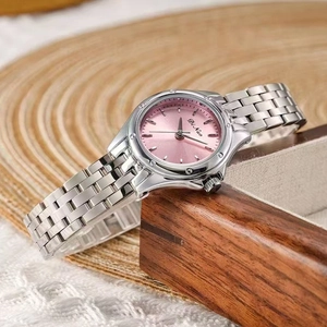 Élégante montre femme en acier inoxydable avec cadran rose sur un support en bois