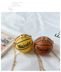 Detail of mini basketball shaped crossbody bags in yellow and brown with gold chains