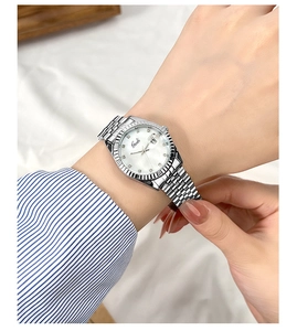 Dettaglio dell'orologio in acciaio argento con indici in cristallo e datario sul polso
