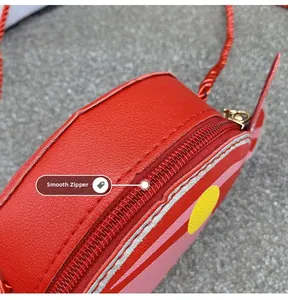 Detail view of smooth zipper and textured red leather on children's candy shoulder bag