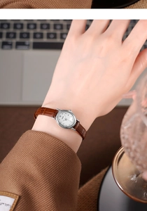 Close-up of GEDI vintage small round watch with brown leather strap worn on wrist
