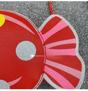 Close-up of red cartoon fish bag showing leather texture and stitching detail