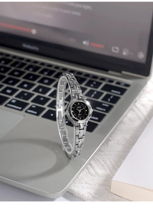 Gros plan d'une montre bracelet en alliage argenté avec cadran noir sur bureau