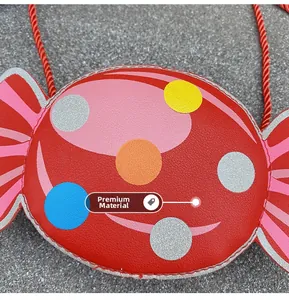 Detail of candy-shaped red leather crossbody bag with colorful dots and woven strap
