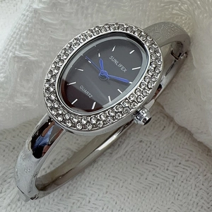 Montre bracelet quartz ovale pour femme avec strass étincelants et finition métal argenté