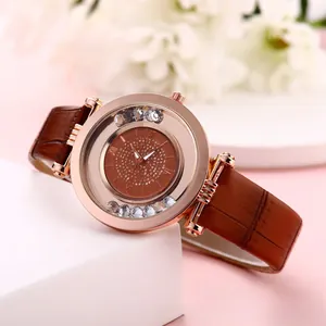 Detail of rose gold quartz watch with floating crystals and brown leather band