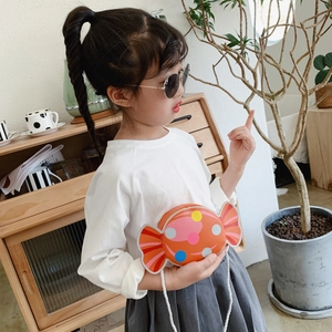 Cute candy-shaped orange crossbody bag for children with colorful polka dots and red trim