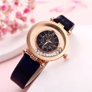 Detail of rose gold watch featuring floating crystals and a blue crocodile leather strap