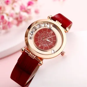 Close-up of red leather watch band with rose gold case and sparkling crystal dial