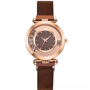 Detail of rose gold quartz watch with rolling rhinestones and brown Milanese mesh band