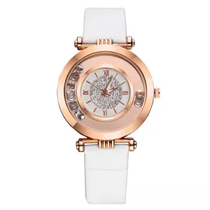 Close-up of rose gold watch dial with sparkling crystals and white leather strap