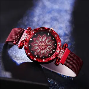 Gros plan d'une montre rouge pour femme avec lunette strass et cadran floral diamant