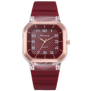 Détail d'une montre à quartz carrée avec bracelet en silicone bordeaux et lunette dorée